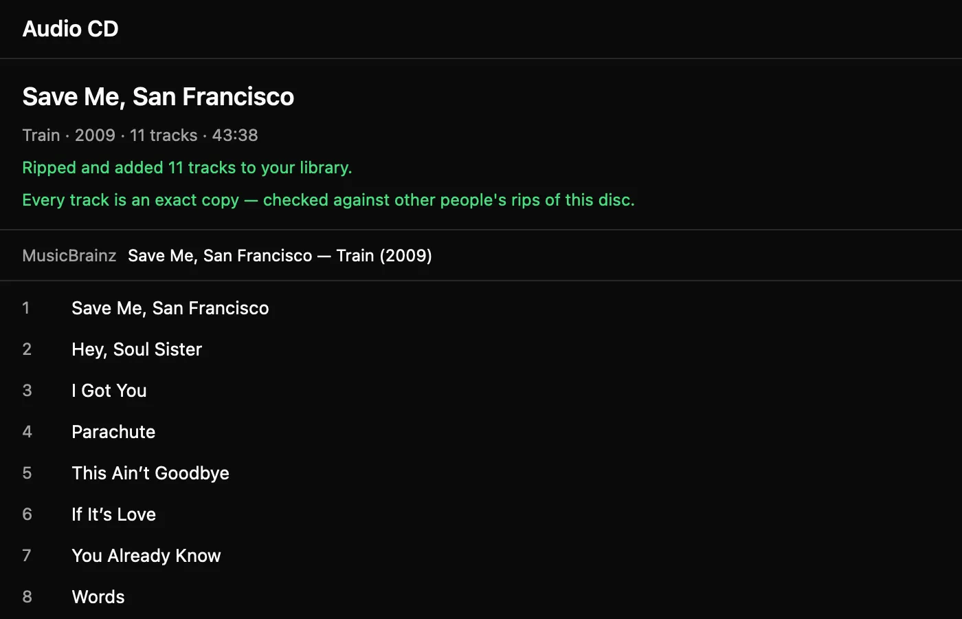 The disc view after a rip: the album identified by MusicBrainz with its eleven tracks listed, and two lines in green reading “Ripped and added 11 tracks to your library” and “Every track is an exact copy — checked against other people’s rips of this disc.”